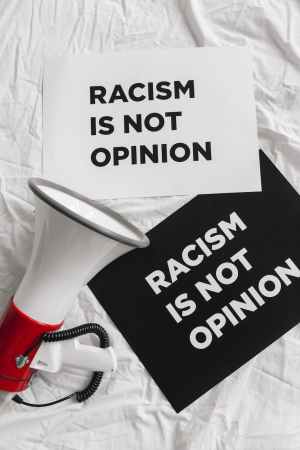 megaphone and placards on racism on white linen