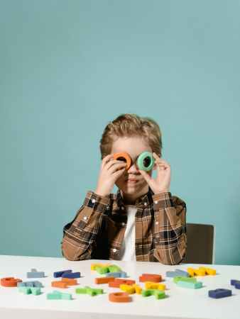 boy in black and white plaid button up shirt holding green and black camera